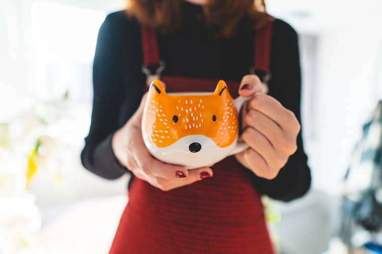 woman holds fox shaped mug