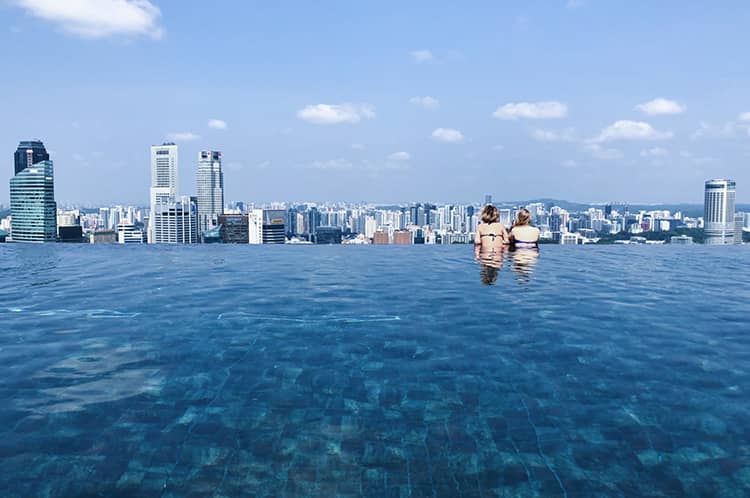 women swimming pool city view