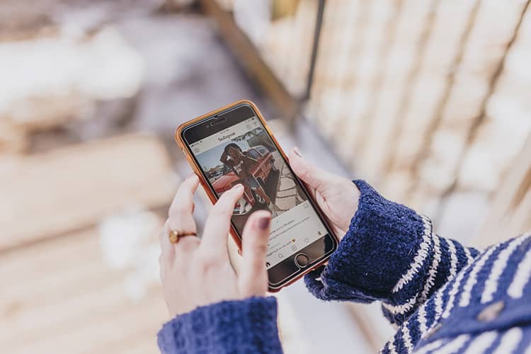 person holds phone photograph instagram feed