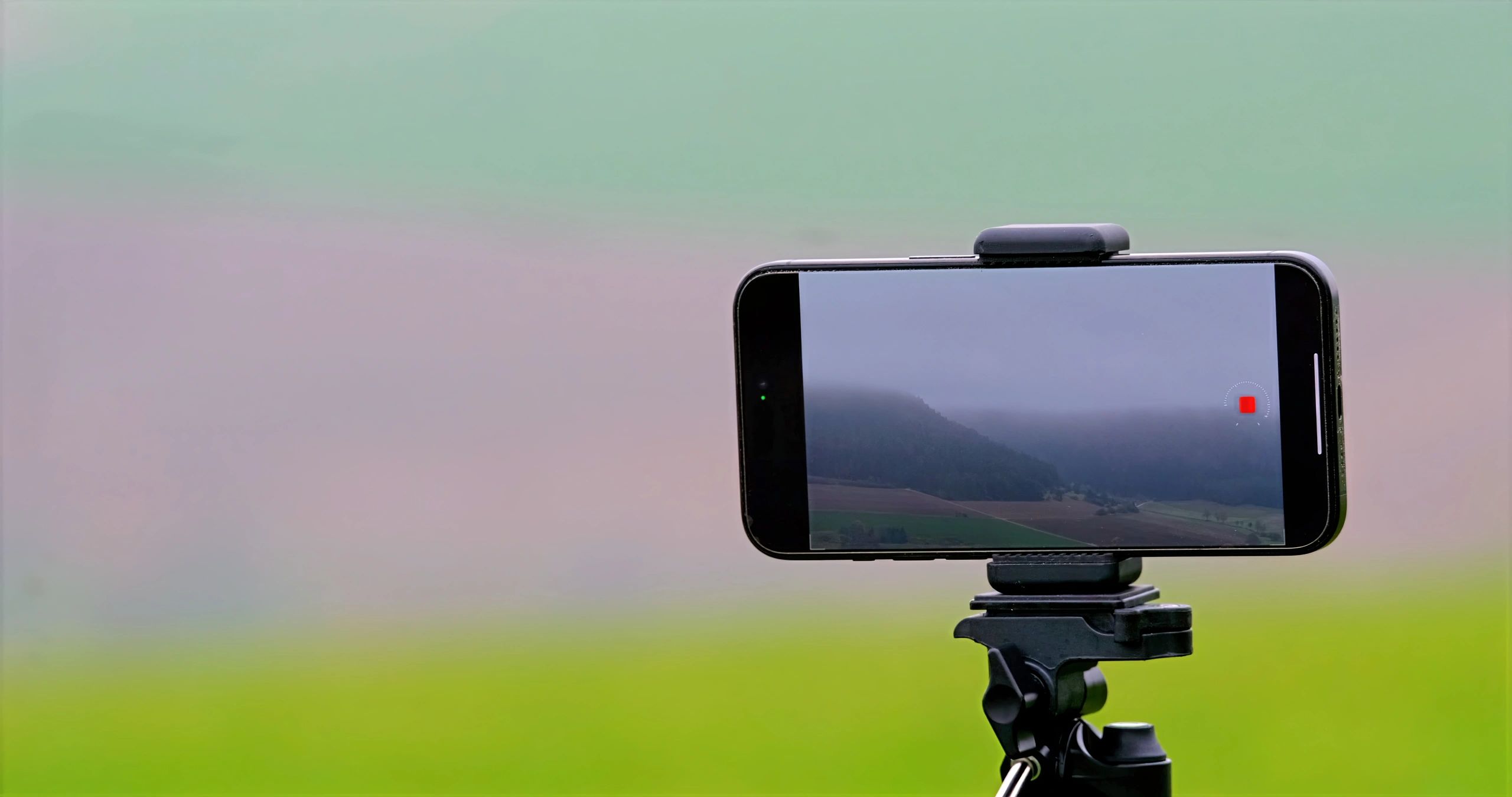 Ponsel pintar di tripod menampilkan layar digital